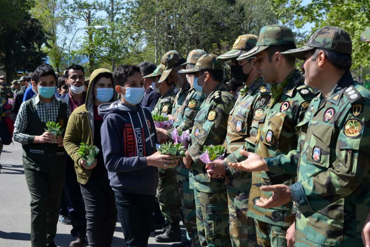 اهدای شاخه های گل از سوی دانش آموزان به ارتشیان لشکر ۱۶ زرهی قزوین
